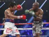 Manny Pacquiao, left, of the Philippines shields himself as Timothy Bradley throws a punch during the WBO welterweight title boxing fight Saturday, April 12, 2014, in Las Vegas. (AP Photo/Eric Jamison)