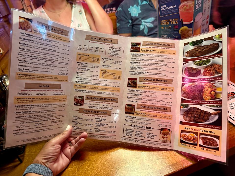 Texas Roadhouse menu in woman's hand at restaurant