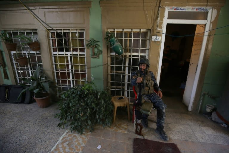 A member of the Iraqi security forces sits in the courtyard of a house on the front line in Mosul's Old City on May 3, 2017