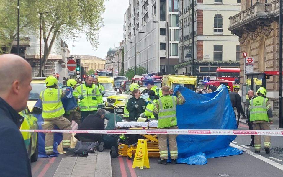 A soldier is attended to by emergency services in Buckingham Palace Road