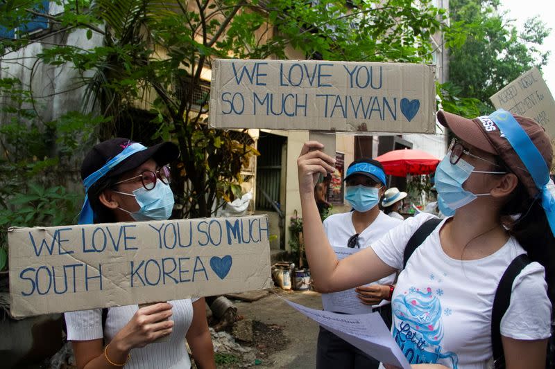 Demonstrators carry placards as they march during a protest against military coup, in Yangon