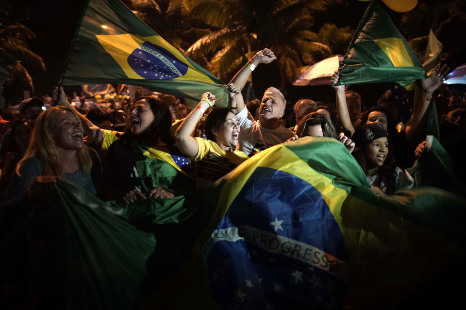 Supporters of Jair Bolsonaro celebrate in front of his residence in Rio de Janeiro, Brazil, Sunday, Oct. 28, 2018. The far-right congressman took a commanding lead in the race for Brazil's presidency, as voters apparently looked past warnings that the brash former army captain would erode democracy and embraced a chance for radical change after years of turmoil. (AP Photo/Leo Correa)