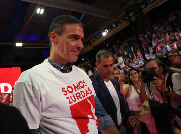 El presidente español Pedro Sánchez se pone la camiseta con la palabra 