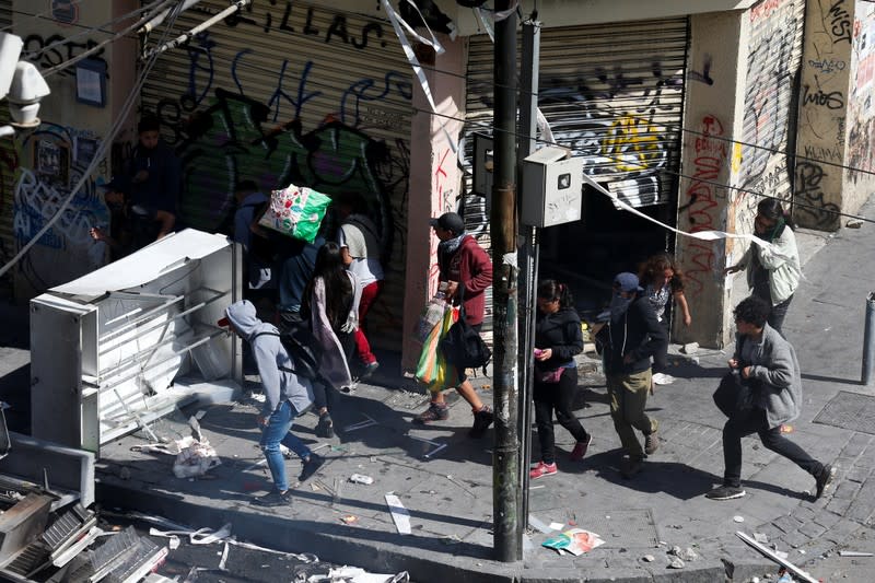 People carry looted goods in Valparaiso