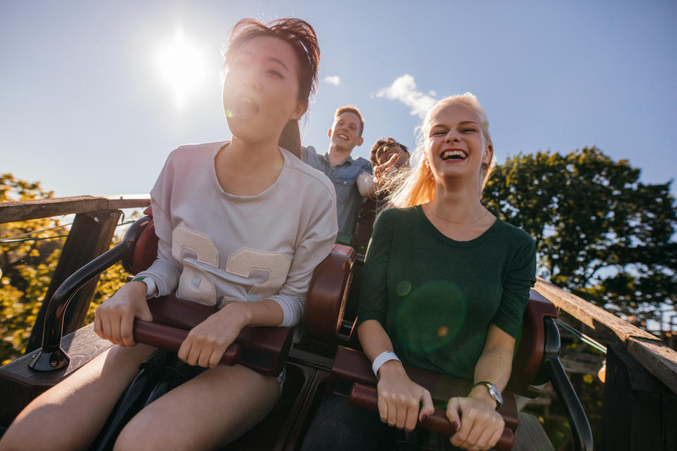 Young adults enjoying a roller coaster ride.