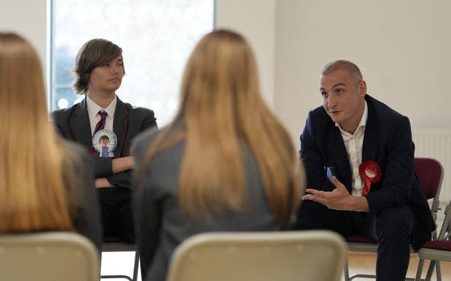 Tom Collinge sitting down as he speaks to pupils