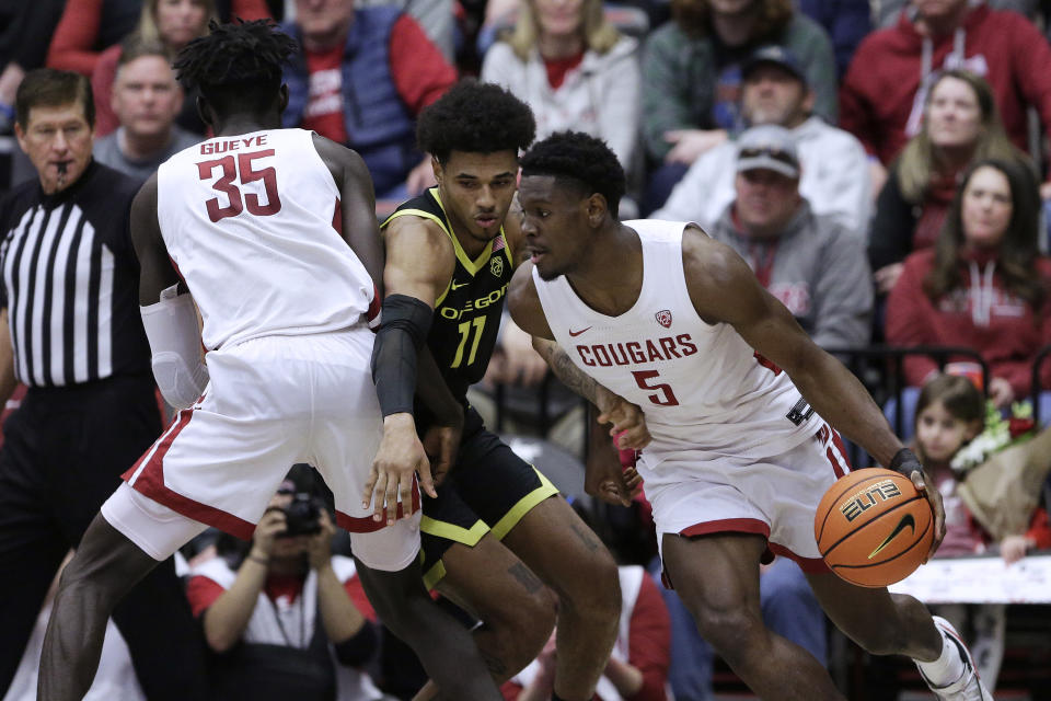 Oregon guard Rivaldo Soares (11) tries to get around a screen set by Washington State forward Mouhamed Gueye (35) while defending guard TJ Bamba (5) during the second half of an NCAA college basketball game Sunday, Feb. 19, 2023, in Pullman, Wash. Washington State won 68-65. (AP Photo/Young Kwak)