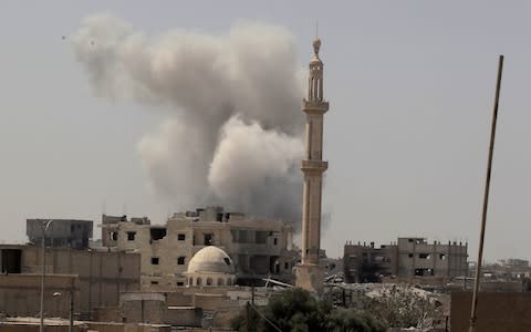 Smoke rises after an air strike during fighting between members of the Syrian Democratic Forces and Islamic State militants in Raqqa - Credit: Reuters