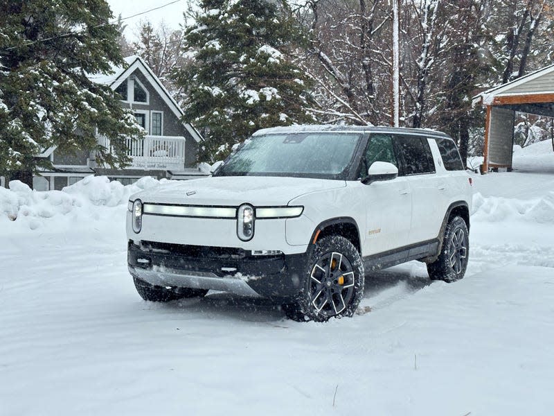 Front 3/4 view of a white Rivian R1S in the snow
