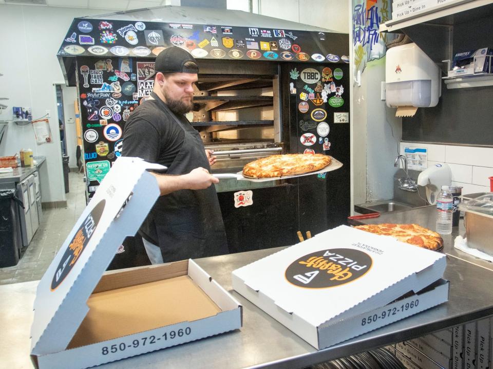 Colton Greer prepares pizzas for take-out at Graffiti Pizza in downtown Pensacola on Wednesday, March 18, 2020.Gregg Pachkowski, gregg@pnj.comColton Greer prepares pizzas for take-out at Graffiti Pizza in downtown Pensacola on Wednesday, March 18, 2020.