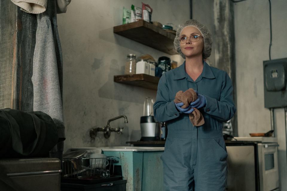 christina ricci as misty from yellowjackets wearing blue scrubs and a hair net