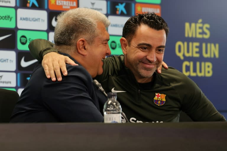 El presidente del FC Barcelona Joan Laporta (izquierda) y el entrenador Xavi Hernández durante la conferencia de prensa en la que ambos explicaron los motivos para la continuidad del técnico, en las instalaciones del club en Sant Joan Despí, cerca de Barcelona, el 25 de abril de 2024 (LLUIS GENE)