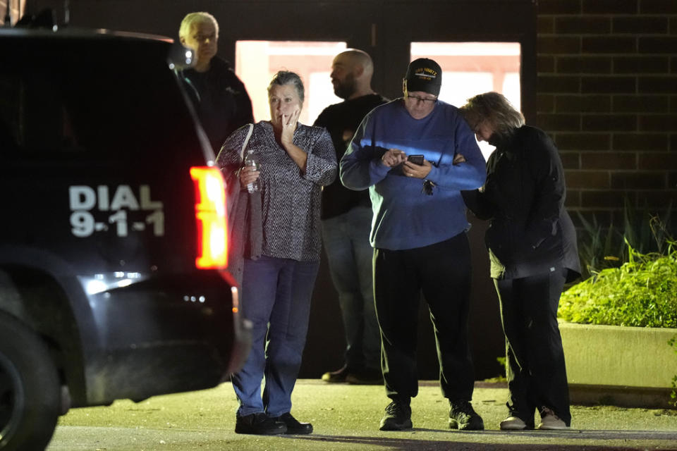 People depart a reunification center early Thursday, Oct. 26, 2023, at Auburn Middle School, in Auburn, Maine, after shootings in Lewiston. (AP Photo/Steven Senne)