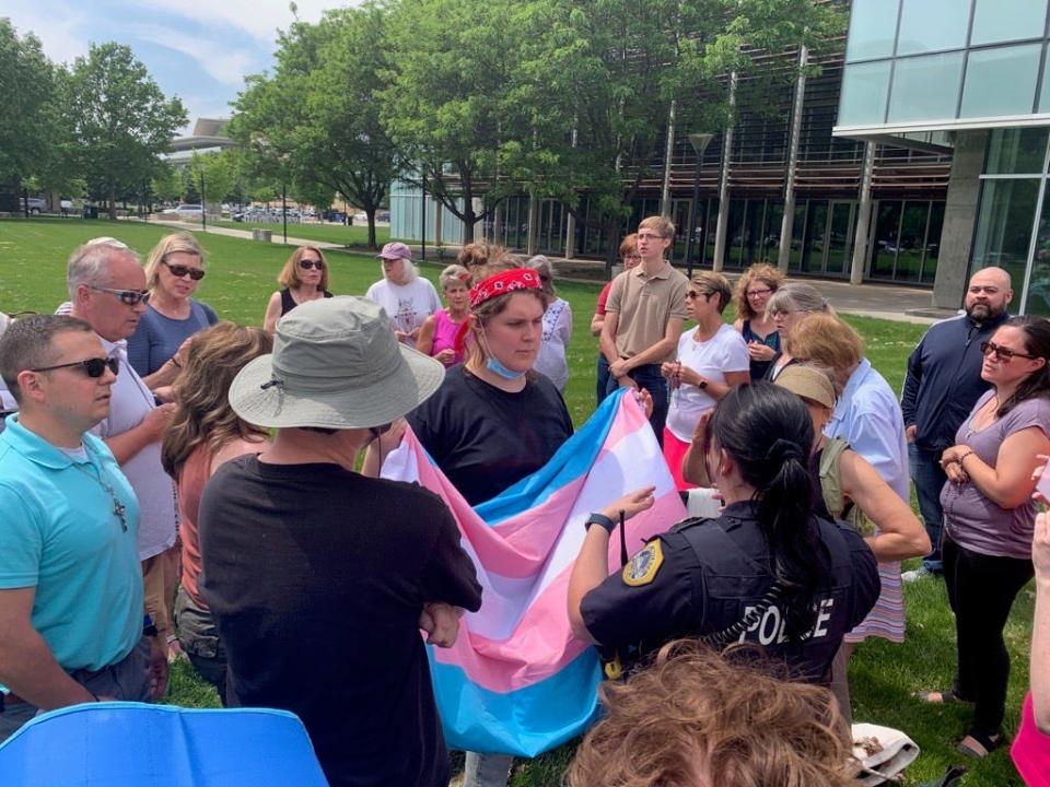 A Trans woman who interrupted a prayer circle is stopped by a Des Moines Police Officer outside of a drag story hour Sunday, May 21 at the Des Moines Central Public Library.