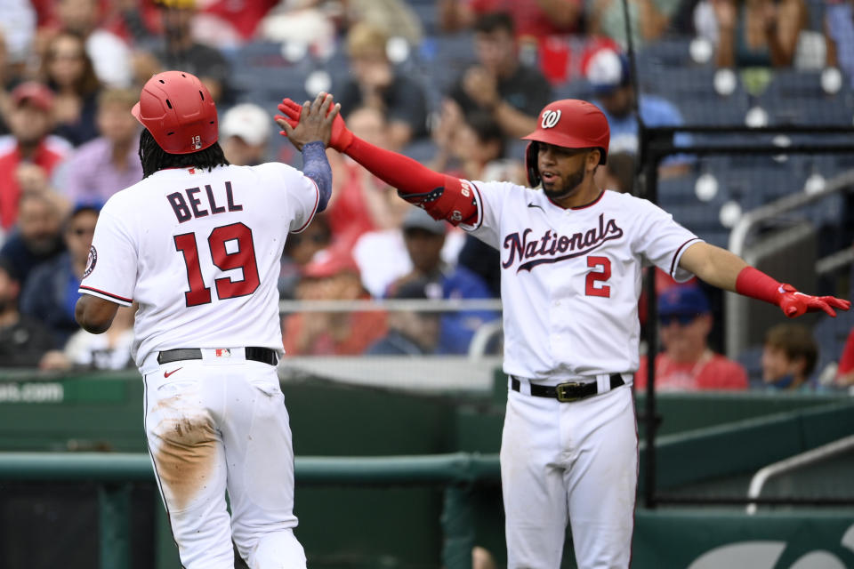 Washington Nationals' Josh Bell (19) is greeted by Luis Garcia (2) as he scores on a single by Yadiel Hernandez during the third inning of a baseball game against the Chicago Cubs, Sunday, Aug. 1, 2021, in Washington. (AP Photo/Nick Wass)