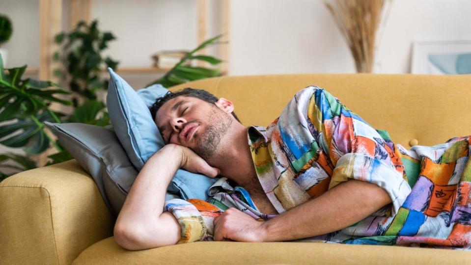 Man sleeping on sofa at home.