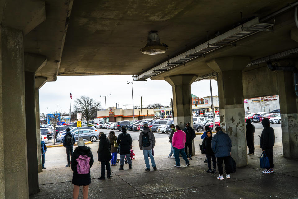 People wait for a bus near the train station, Tuesday, March 26, 2024, in Freeport, N.Y. In Long Island's Nassau County, a handful of Latino residents and a local civil rights organization allege that a redistricting map drawn by the county Legislature dilutes the voting power of Black, Latino and Asian residents. (AP Photo/Eduardo Munoz Alvarez)