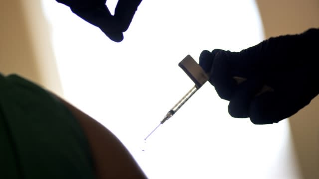 A droplet falls from a syringe after a health care worker was injected with the Pfizer-BioNTech COVID-19 vaccine