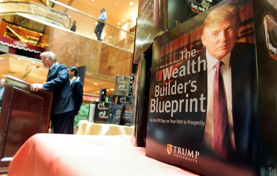 Course material is displayed while Donald Trump speaks at a news conference announcing the establishment of Trump University in 2005. (Photo: Mario Tama/Getty Images)