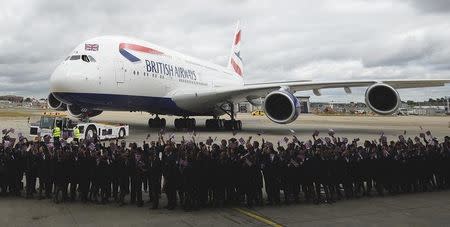 Workers welcome British Airways' new Airbus A380 as it taxis to a hanger after landing at Heathrow airport in London July 4, 2013. REUTERS/Paul Hackett