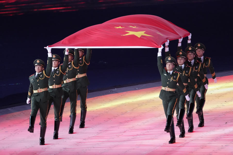 Military carry the Chinese flag during the opening ceremony of the 19th Asian Games in Hangzhou, China, Saturday, Sept. 23, 2023. (AP Photo/Eugene Hoshiko)