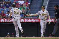 Oakland Athletics' Matt Olson, left, is congratulated by Matt Chapman after he scored on a sacrifice fly by Jed Lowrie during the 10th inning of a baseball game against the Los Angeles Angels, Sunday, Sept. 19, 2021, in Anaheim, Calif. (AP Photo/Jae C. Hong)