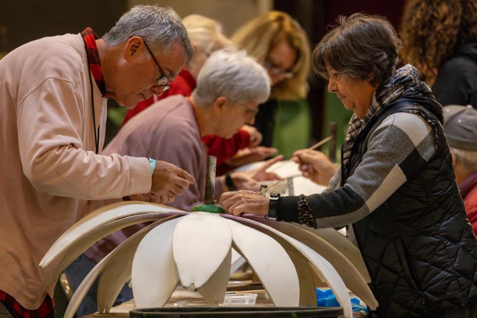 Tim Desjean, left, Elsa Goodman and other volunteers work on Torrence