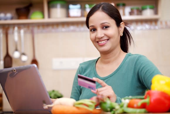 Woman with credit card in front of a laptop