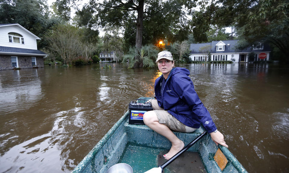 <p>Jeanni Adame rides in her boat as she checks on neighbors seeing if they want to evacuate in the Ashborough subdivision near Summerville, S.C., after many of their neighbors left, Monday, Oct. 5, 2015. South Carolina is still struggling with flood waters due to a slow moving storm system. (AP Photo/Mic Smith) </p>