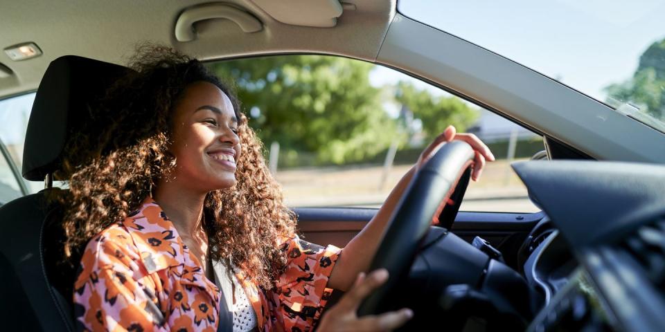 smiling young woman driving car