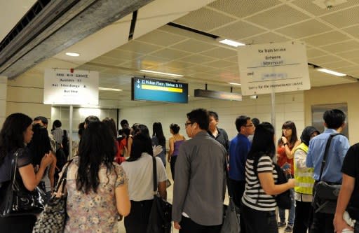 Commuters gather next to the escalator leading to the SMRT circle line train at Bishan station interchange during a disruption on 18 April.(AFP photo)