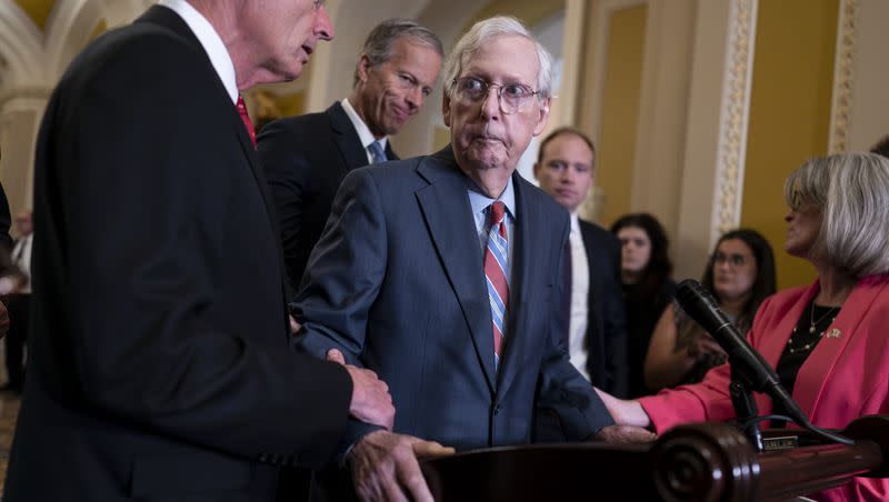 Senate Minority Leader Mitch McConnell, R-Ky., center, is helped by, from left, Sen. John Barrasso, R-Wyo., Sen. John Thune, R-S.D., and Sen. Joni Ernst, R-Iowa, after the 81-year-old GOP leader froze at the microphones as he arrived for a news conference, Wednesday, July 26, 2023, at the Capitol in Washington.