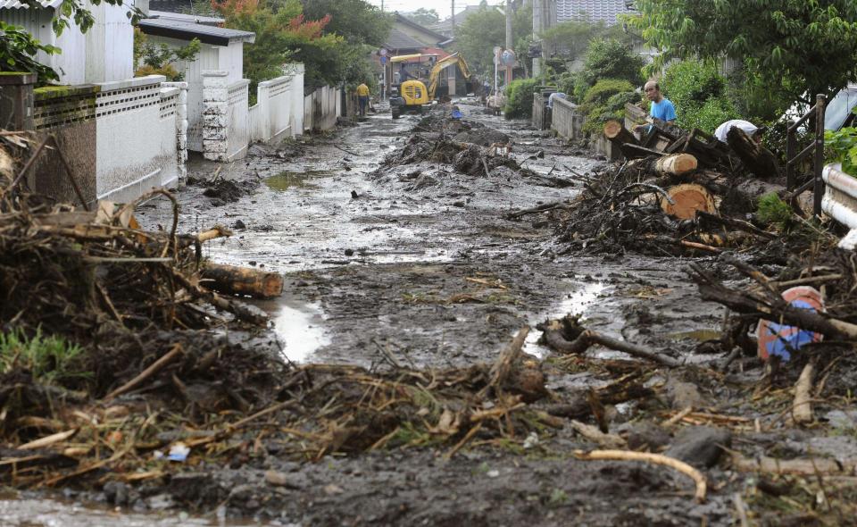 A road is covered with mud and woods carried by a mudslide in Aso, Kumamoto Prefecture, western Japan, Thursday, July 12, 2012. Heavy rains hit southern Japan, triggering flashfloods, mudslides and destroying dozens of homes. (AP Photo/Kyodo News) JAPAN OUT, MANDATORY CREDIT, NO LICENSING IN JAPAN, CHINA, HONG KONG, SOUTH KOREA AND FRANCE