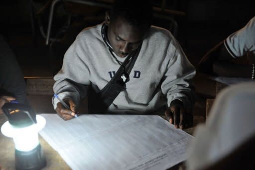 A man takes notes at a polling station in Dakar during the counting of votes. Senegal began tallying results in a contentious election in which incumbent Abdoulaye Wade, who is seeking to extend his rule with a disputed third term, was greeted by jeers as he cast his ballot Sunday