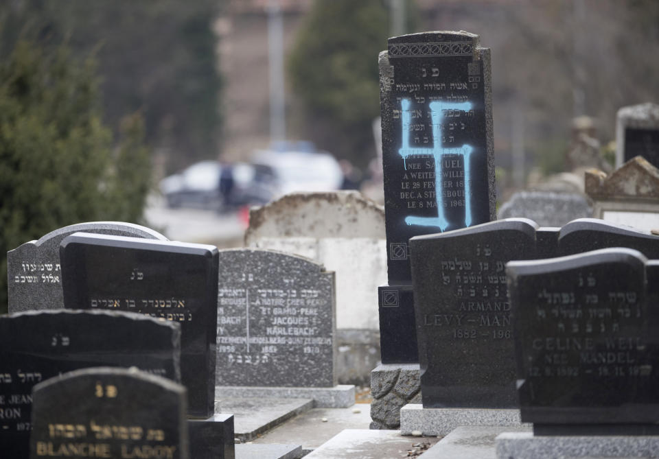 A vandalized tomb, tagged with a swastika, is pictured in the Jewish cemetery of Quatzenheim, eastern France, Tuesday, Feb.19, 2019. Marches and gatherings against anti-Semitism are taking place across France following a series of anti-Semitic acts that shocked the country. (AP Photo/Jean-Francois Badias)