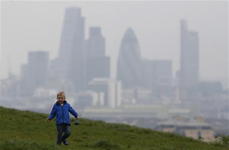 Daniel Buttery, 4, plays in Greenwich Park as a haze of pollution sits over the London skyline April 3, 2014. REUTERS/Luke MacGregor