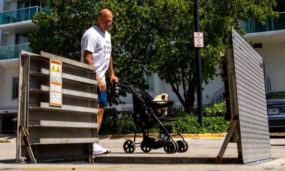 Miami Beach resident Sean Cassidy, 56, peeks into the open trash rack near 10th Street and West Avenue while on a stroll with his dog Snoop, on Wednesday, May 25, 2022. The trash rack is the first station to intercept trash and debris for treatment of stormwater runoff before ultimately being dissipated into the bay.