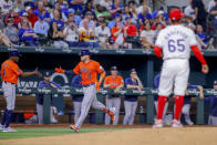 Houston Astros' third base coach Gary Pettis (8) high-fives Victor Caratini (17) for hitting a three-run home run off of Texas Rangers pitcher Grant Anderson (65) during the fifth inning of a baseball game, Monday, April 8, 2024, in Arlington, Texas. (AP Photo/Gareth Patterson)