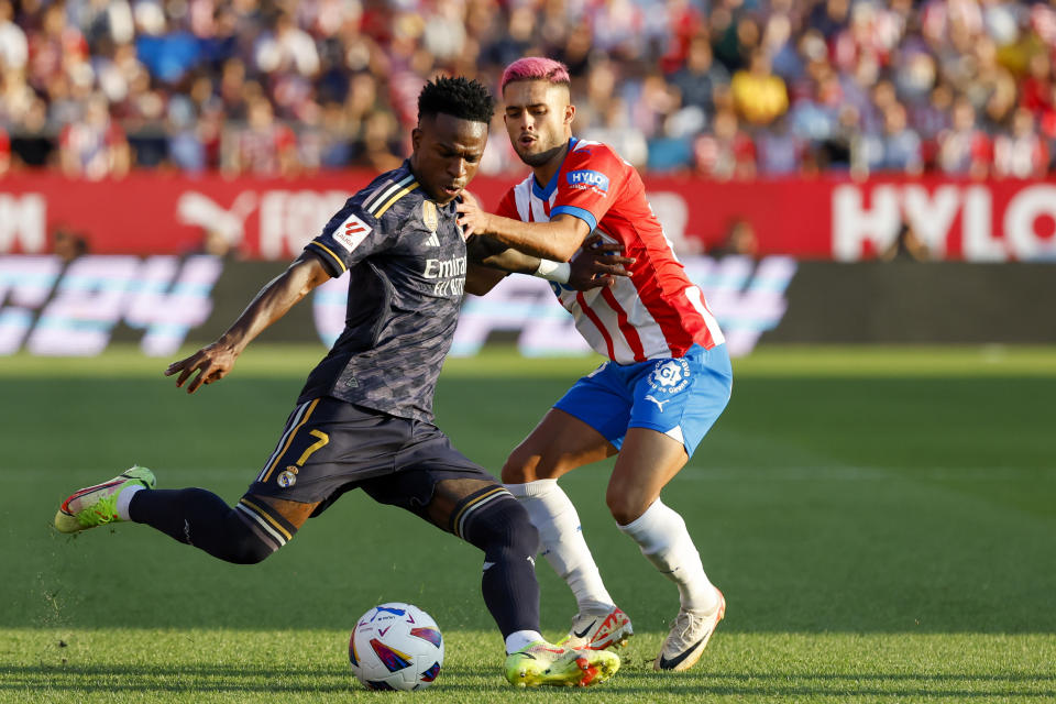 FILE - Real Madrid's Vinicius Junior, left, duels for the ball with Girona's Yan Couto during a Spanish La Liga soccer match between Girona and Real Madrid, at the Montilivi stadium in Girona, Spain, Saturday, Sept. 30, 2023. Girona’s chief executive was hoping at the start of the season that his team could simply avoid relegation from Spanish soccer's top tier. So Ignasi Mas-Baga tells The Associated Press that he is surprised as anyone to see the team from the northeast corner of Spain leading the standings a third of the way through the season. (AP Photo/Joan Monfort, File)