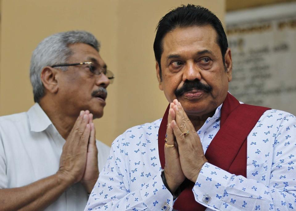 FILE- In this Feb. 8, 2016 file photo, former Sri Lankan President Mahinda Rajapaksa, right, and former Defense Secretary and his brother Gotabaya Rajapaksa, offer prayers during a function organized to sign a petition against UN recommended investigation into alleged war atrocities in Colombo, Sri Lanka. Nandasena Gotabaya Rajapaksa, who was a livewire in Sri Lanka's military campaign to end a long civil war but faces allegations of human rights violations, has been nominated as the opposition's candidate for the presidential election scheduled for later this year. (AP Photo/Eranga Jayawardena, File)