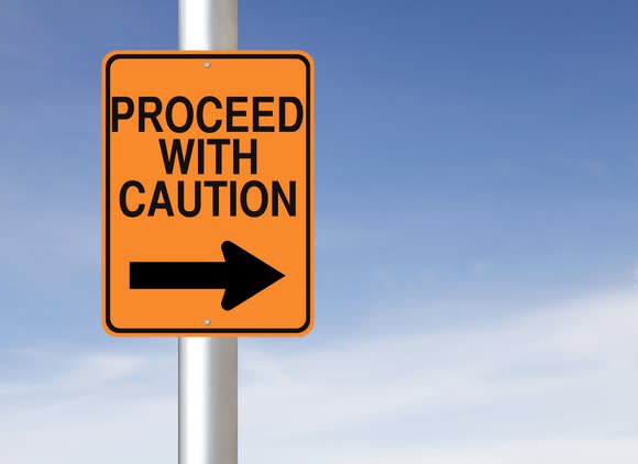 road sign that says proceed with caution and has arrow pointing to the right