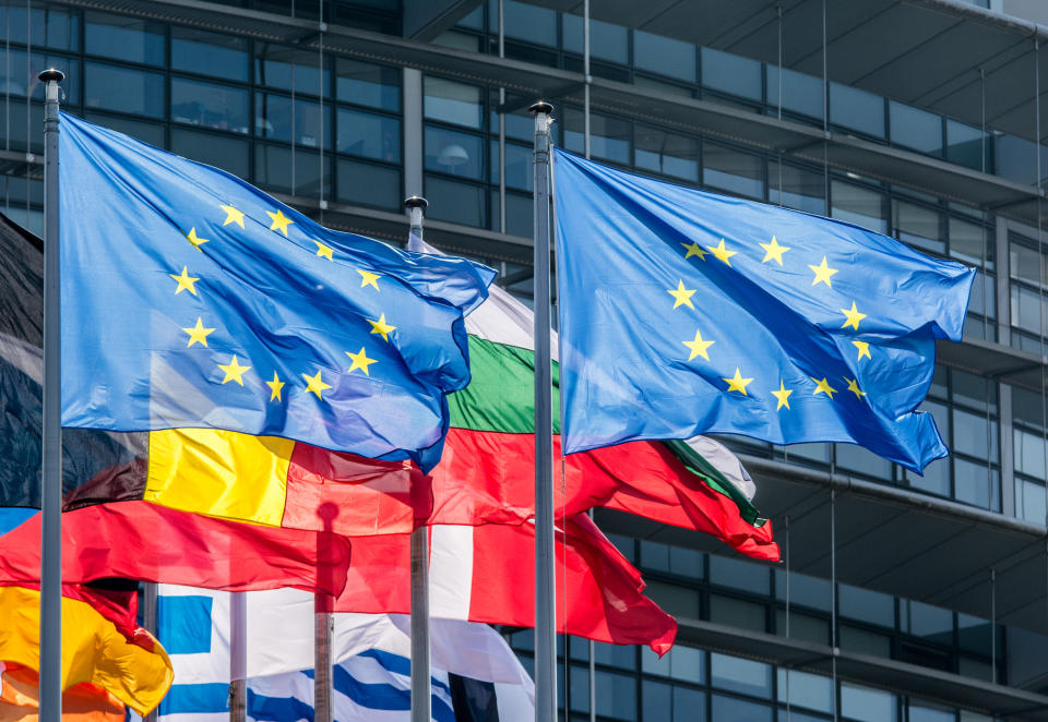 European Union flags flying outside a building.