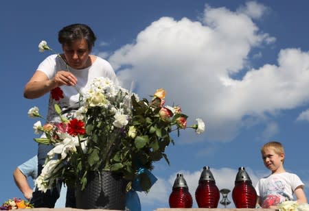 A woman places flowers next to the Margaret bridge in respect for the victims of a boat accident involving South Korean tourists on the Danube river, in Budapest