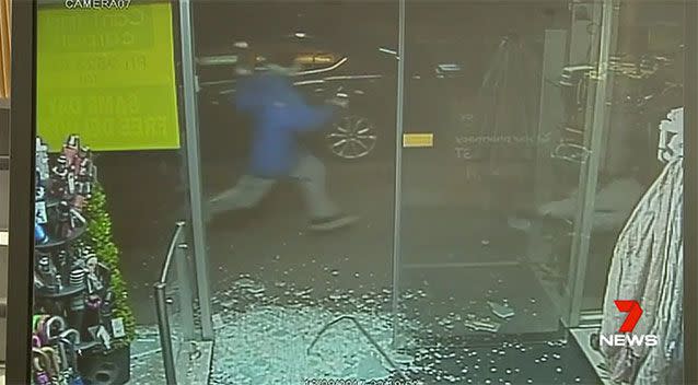 Mr Lee tries to run away but falls as the burglar (in blue) approaches him. Source: 7 News