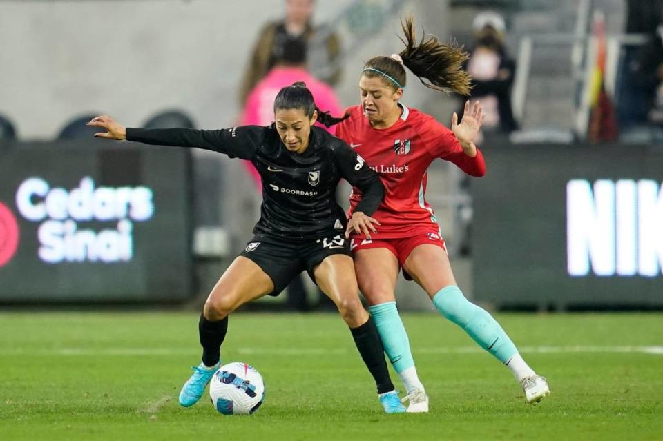 Angel City FC forward Christen Press, left, and Kansas City Current midfielder Alexis Loera fight for the ball during Saturday night’s NWSL soccer match in Los Angeles.