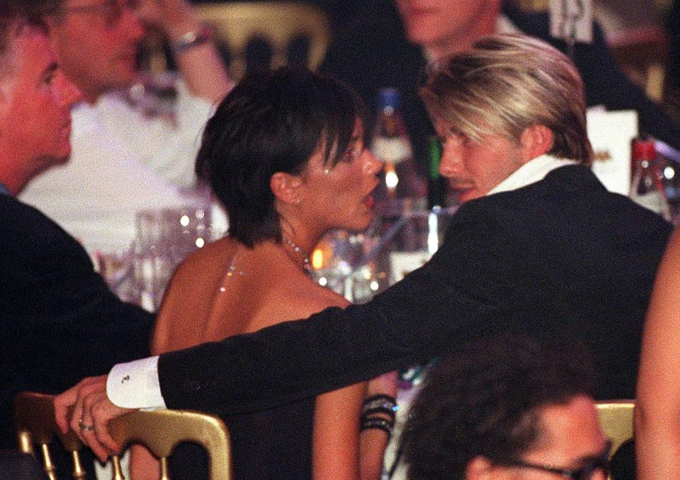 Victoria Beckham speaks to David Beckham at a music award show on October 6, 1999