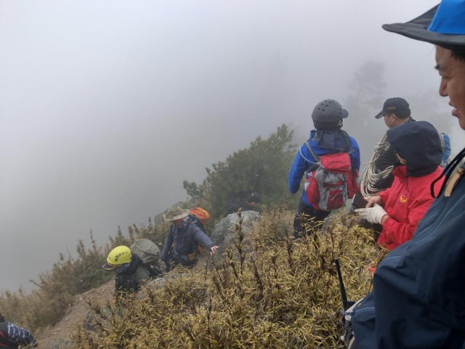 南投縣信義鄉發生山難死亡意外，34歲黃姓女子和友人攀登郡大山，登頂折返時失蹤，南投縣消防局派出搜救人員入山進行搜救（圖），27日下午發現黃女遺體，陸續由直升機協助將遺體吊掛下山。（翻攝照片）