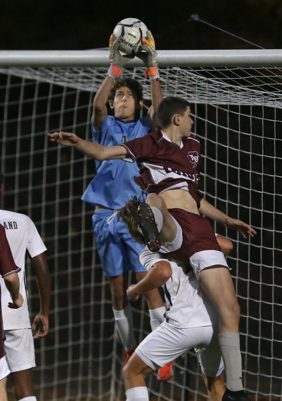 Sutherland keeper Seth Rozen pulls down a corner kick over Aquinas's John Leary during their Section V Class A championship final Friday, Oct. 27, 2023 at Spencerport.