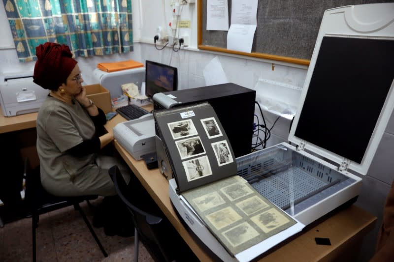 A employee demonstrates the scanning process of photographs during an interview with Reuters at the offices of Shem Olam Holocaust Memorial Centre in Kfar Haroeh, Israel