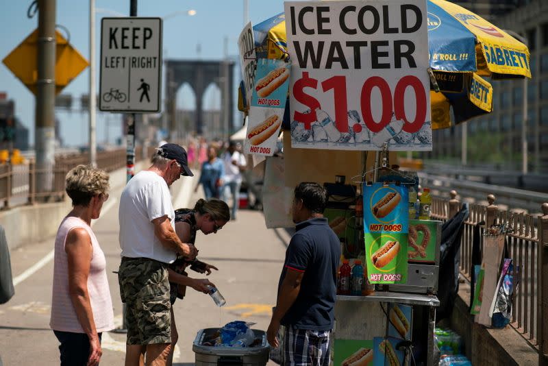 People buy cold water during a heat wave at the Brooklyn Bridge in New York
